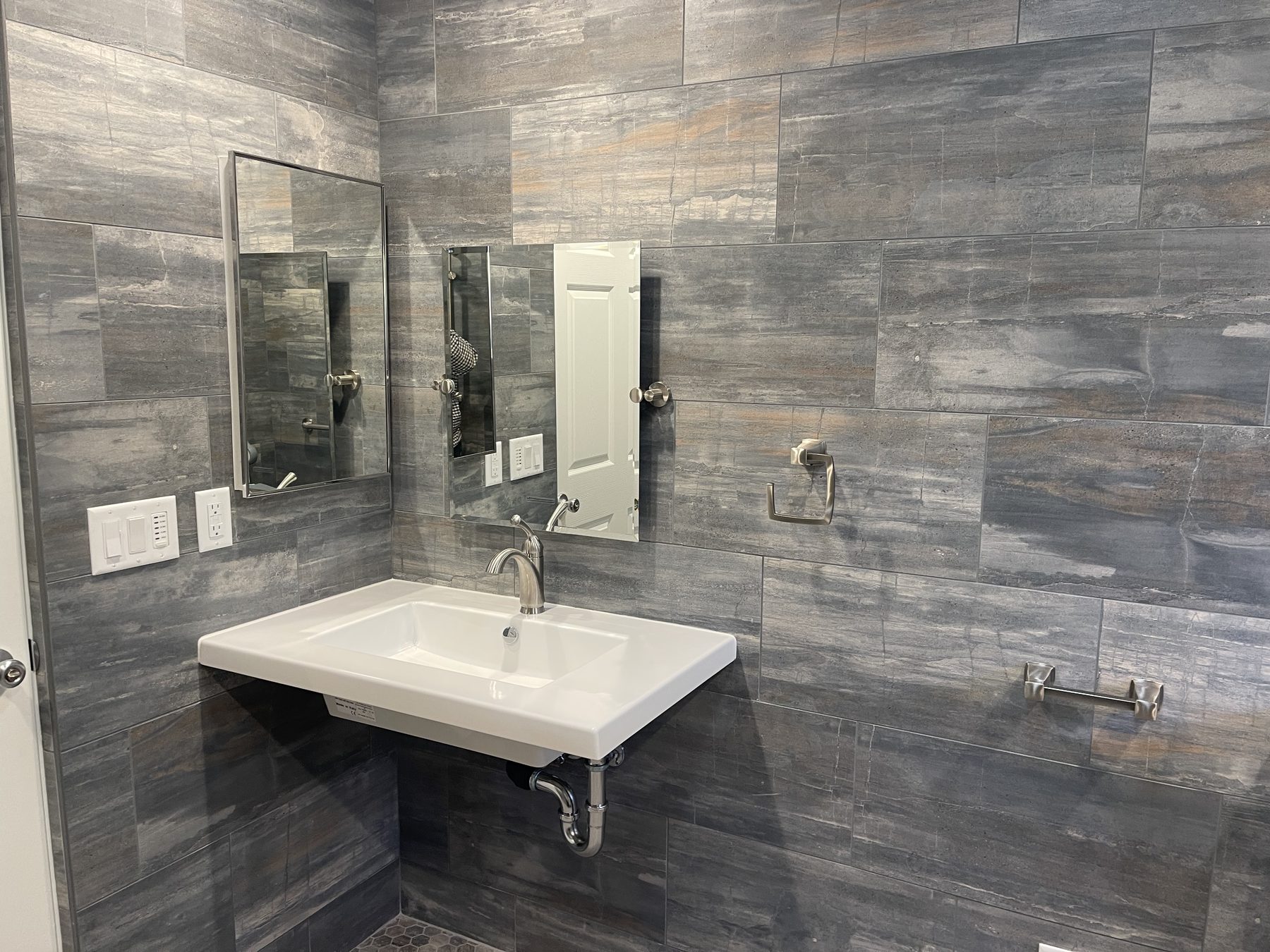 Bathroom remodel with gray wood-look tile, floating vanity, and walk-in shower in Monterey County