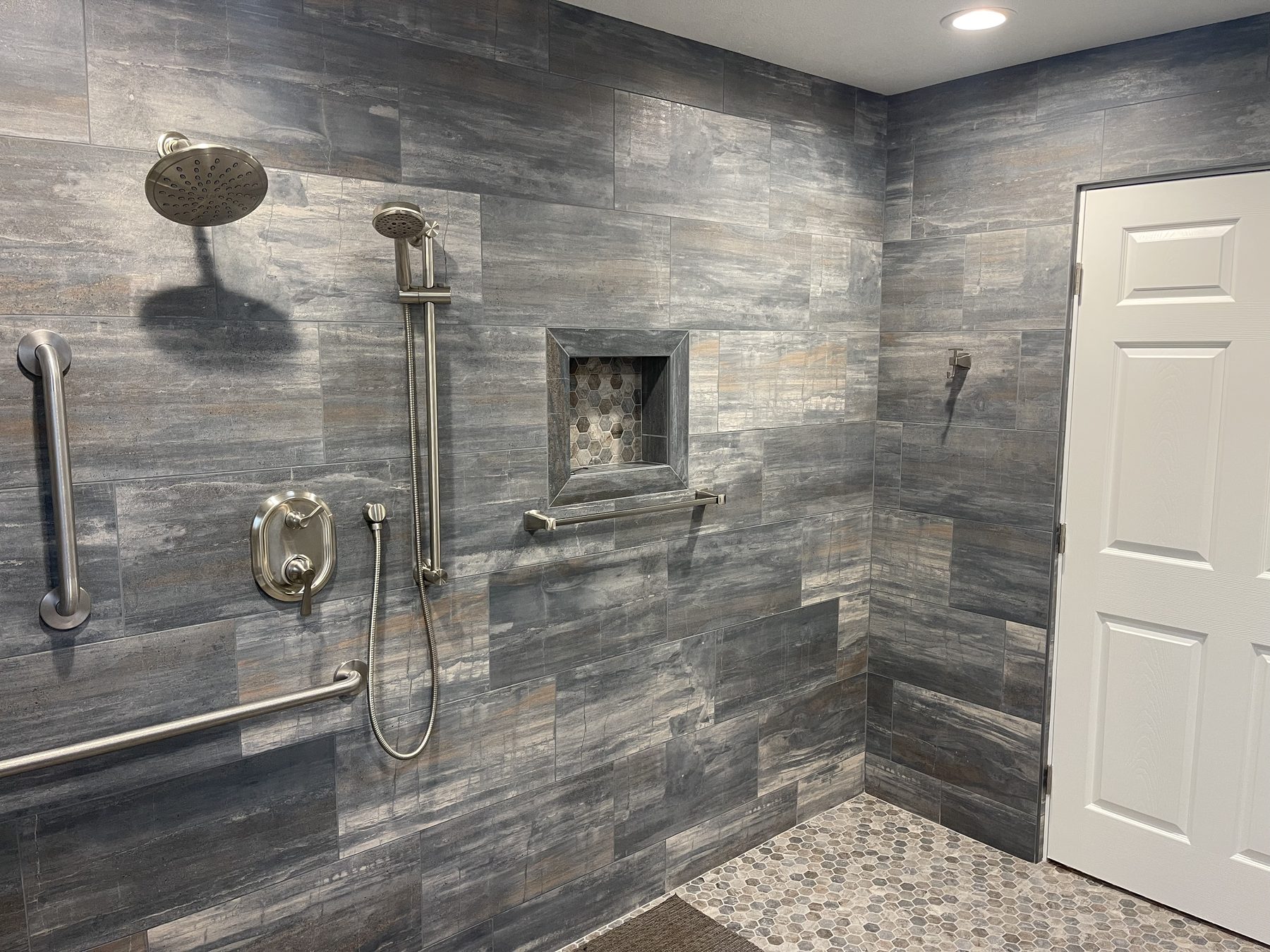 Completed bathroom remodel with custom tilework and curbless shower entry