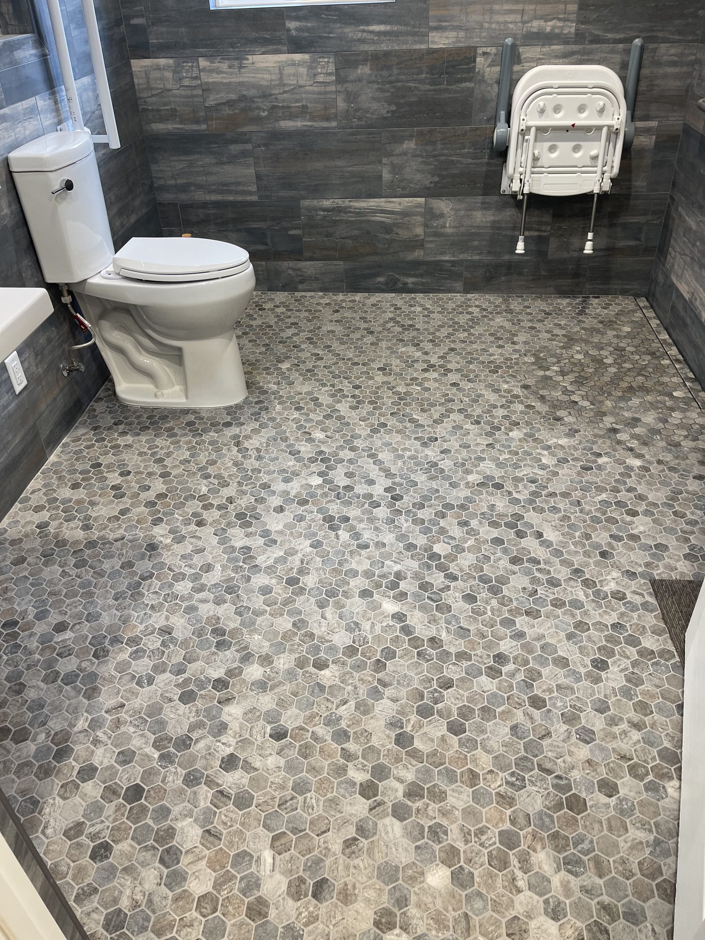 Accessible bathroom remodel with curbless walk-in shower, grab bars, and roll-under sink in Monterey County